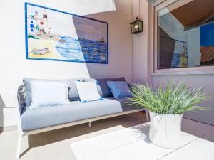 a couch in a living room with a painting at Elite Bonaire Penthouse by Hello Homes Sitges in Sitges
