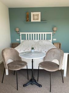 - une table et des chaises dans une chambre avec un lit dans l'établissement Divi Divi Zandvoort, à Zandvoort