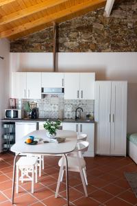 uma cozinha com armários brancos e uma mesa e cadeiras em A CASA DA VILA em Almodôvar