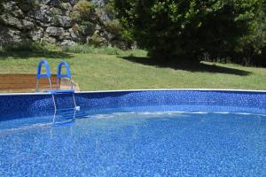 dos sillas azules sentadas en una piscina azul en Castello Montesasso, en Mercato Saraceno