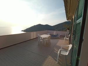 a balcony with a table and chairs and the ocean at Casa Orchidea - Vista Mare meravigliosa in Bonassola