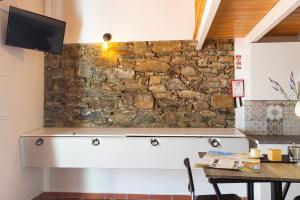 a stone wall in a kitchen with a table at A CASA DA VILA in Almodôvar