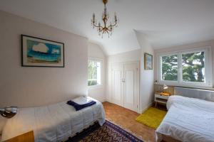 ein Schlafzimmer mit zwei Betten und einem Kronleuchter in der Unterkunft Ty Maine in Carantec