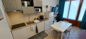uma pequena cozinha com uma mesa e um micro-ondas em La Casa delle Camelie em Stresa