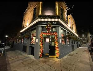 a building with a christmasreath on the front of it at Dockers Inn in London