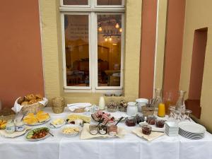 a white table with plates of food on it at Kapitänshaus in Bad Schandau