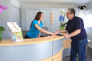 a man and a woman shaking hands at a counter at Camping maeva Club Les Préveils in La Tranche-sur-Mer +91 photos