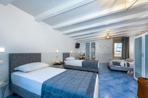サン・ヴィート・ロ・カーポにあるAlbert Rooms & Breakfastのベッド2台とソファが備わるホテルルームです。