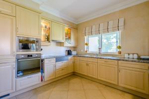 a large kitchen with wooden cabinets and appliances at Casa Sunny Days - Boavista Resort in Lagos