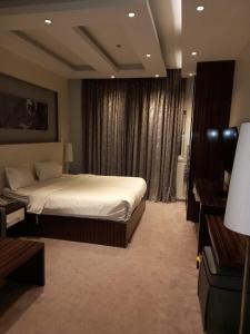 een slaapkamer met een groot bed in een hotelkamer bij Taleen Hotel in Riyad