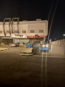 a parking lot in front of a building at night at Taleen Hotel in Riyadh