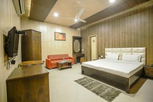 1 dormitorio con 1 cama, TV y sofá en Hotel HK Continental, en Amritsar