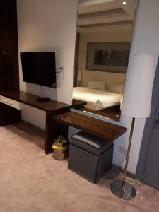 a bedroom with a desk with a computer and a bed at Taleen Hotel in Riyadh