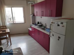 a kitchen with purple cabinets and a white refrigerator at Square 2 in Komotini