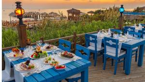 a table with plates of food on a deck with the beach at Sunrise Resort Hotel in Kizilagac