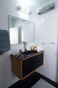 ein Bad mit einem schwarzen Waschbecken und einem Spiegel in der Unterkunft Prestige Room in Prestige location Bahai's Garden in Haifa