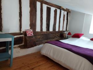 ein Schlafzimmer mit einem Bett und einer Holzwand in der Unterkunft Studio Bellevue 3 rue du bourg a Montastruc 47380 entrée indépendante in Montastruc
