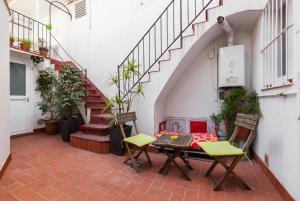 eine Terrasse mit einem Tisch, Stühlen und Treppen in der Unterkunft Monlau 12 in Barcelona