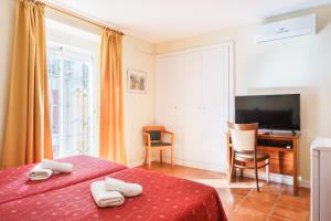 1 dormitorio con 2 camas, escritorio y TV en Hotel Carlos V Jerez by Vivere Stays, en Jerez de la Frontera