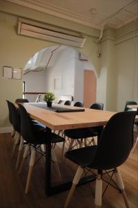 CarricHostel في ملبورن: قاعة اجتماعات مع طاولة وكراسي خشبية