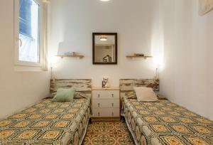 um quarto com duas camas e um espelho na parede em El Patio de Gracia em Barcelona