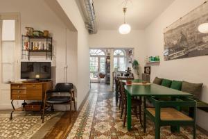 uma sala de estar com uma mesa verde e cadeiras em El Patio de Gracia em Barcelona