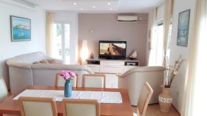 uma sala de estar com uma mesa e uma televisão em Apartments The View - close to the beach & parking em Trogir