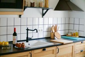 a kitchen with a sink and a bottle of wine at "soñaC soL" in Los Caños de Meca