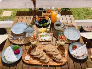 a picnic table with sandwiches and fruit and drinks at Ocean House Alentejo in Porto Covo