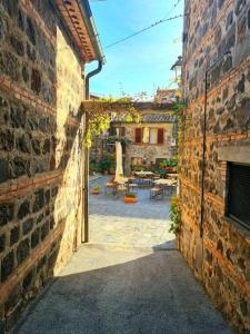 um beco entre dois edifícios de tijolos com um pátio em Flat Ghino di Tacco historical centre Radicofani em Radicofani