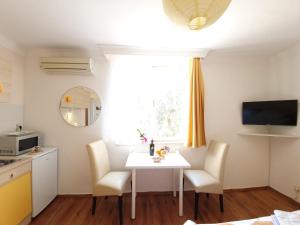 a kitchen with a white table and chairs and a window at Apartments Dabar in Dubrovnik