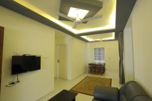a living room with a ceiling fan and a couch at Yelza Hotel and Residence in Alwaye
