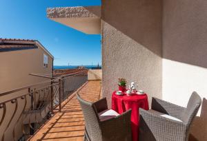 uma mesa com uma toalha de mesa vermelha na varanda em Apps and room Goran in the center em Makarska