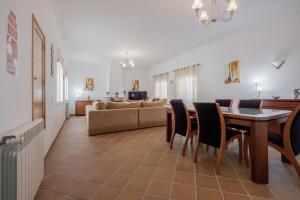 sala de estar con mesa y sofá en Stunning T3 Vila dos Príncipes, en Casal da Lagoa Seca