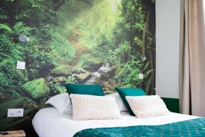 een slaapkamer met een bosmuurschildering aan de muur bij * Les Suites aux Étoiles * in Clermont-Ferrand
