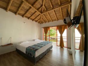 1 dormitorio con cama y ventana grande en Hotel Las Aldeas, en Montenegro