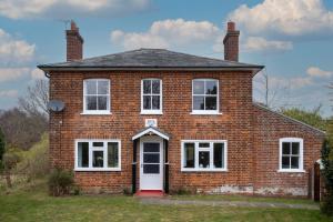 a red brick house with a white door at Mere Cottage - Aldeburgh Coastal Cottages in Thorpeness