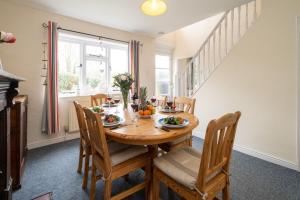 a dining room with a wooden table and chairs at Mere Cottage - Aldeburgh Coastal Cottages in Thorpeness