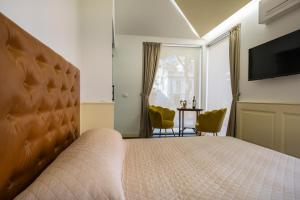 - une chambre avec un grand lit et une télévision dans l'établissement Luxury B&B La Riserva Dannunziana, à Pescara