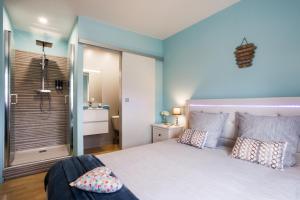 een slaapkamer met een groot bed en een badkamer bij O' Bonheur de l'Olivier Chambres et Gîtes 4 étoiles in Cessenon
