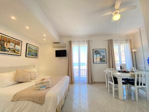 ein Schlafzimmer mit einem Bett und ein Esszimmer mit einem Tisch in der Unterkunft Ma&Mi Guest House in Cefalú