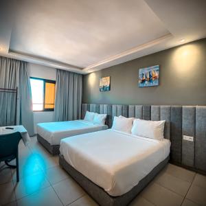 una habitación de hotel con 2 camas en una habitación en Hotel Dakhla Ville, en Dakhla