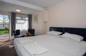 a bedroom with a large white bed and a window at Sutton Vale in Deal