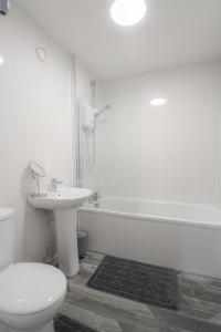 La salle de bains est pourvue de toilettes, d'un lavabo et d'une douche. dans l'établissement Sonas Apartment Greenock, à Greenock