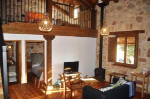 un salon avec un canapé et une chambre avec un lit dans l'établissement El Rinconcillo de Torreiglesias, à Torreiglesias