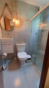 a bathroom with a toilet and a glass shower at Pousada Estrela Cordel in Fernando de Noronha