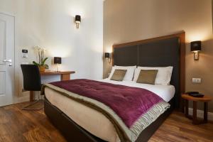 - une chambre avec un grand lit et une couverture violette dans l'établissement L'obelisque maison de luxe, à Rome