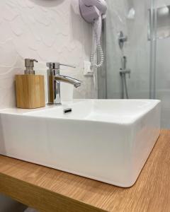 a white sink in a bathroom with a shower at Casa Artesano, appartamento San Michele in Trapani