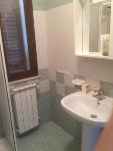 bagno con lavandino, servizi igienici e specchio di Sebastiano. Appartamento a 1,2 km dallo Stagnone a Marsala