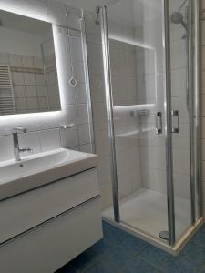 a white bathroom with a shower and a sink at Landhaus am Haff A9 in Stolpe auf Usedom